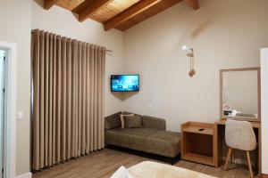 a living room with a couch and a tv on the wall at Arial Penthouse Suites in Vlorë