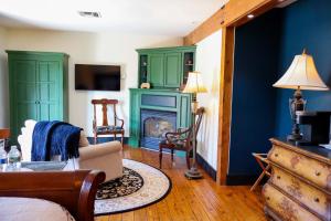 a living room with green cabinets and a fireplace at Stonecroft Inn in Ledyard Center