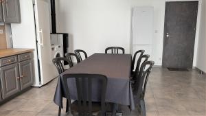 a kitchen with a table with chairs and a refrigerator at Chardonnay in Boyeux-Saint-Jérôme