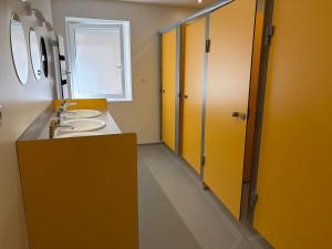 a bathroom with two sinks and yellow cabinets and a window at Chardonnay in Boyeux-Saint-Jérôme