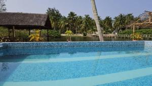 a swimming pool in front of a resort at L'île de Marie-Jo in Assinie