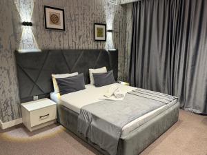 a bedroom with a bed with a gray headboard at Bazarstore Montin Hotel in Baku +92 photos