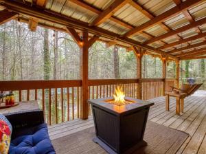 a screened in porch with a fireplace in the middle at Honeymoon Sweet in Townsend