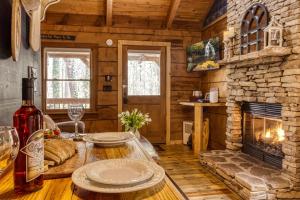 a living room with a stone fireplace in a log cabin at Honeymoon Sweet in Townsend