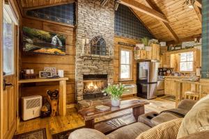 a living room with a stone fireplace in a cabin at Honeymoon Sweet in Townsend