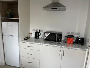 a kitchen with a counter with a microwave and a refrigerator at The C & A Studio in Killala