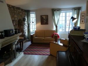 a living room with a couch and a fireplace at GÎTE DU VALAMBOURG in Auvers-sur-Oise