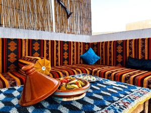 a room with a table with a bowl of food on it at Itrane Hostel in Tamraght Ouzdar