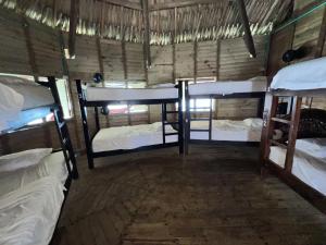 a room with three bunk beds in a house at Casa en el agua in Tintipan Island