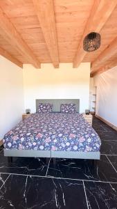 a bed in a bedroom with a wooden ceiling at Domaine des Chênes in Saint-Pierre-les-Étieux