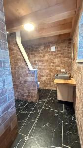 a bathroom with a sink and a brick wall at Domaine des Chênes in Saint-Pierre-les-Étieux