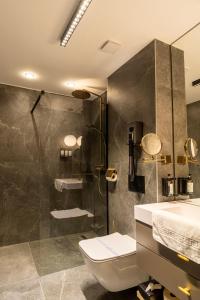 a bathroom with a shower and a toilet and a sink at Hotel Zena Beauty & Shopping Center in Hévíz