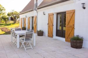 a patio with a table and chairs in front of a house at Domaine des Chênes in Saint-Pierre-les-Étieux +96 photos