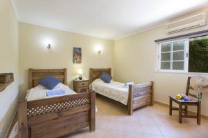 a bedroom with two beds and a window at Villa Teotel by Villa Plus in Almancil +20 photos