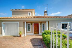 a house with a red door and a white fence at Villa Teotel by Villa Plus in Almancil