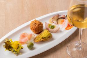 ein Teller Essen und ein Glas Wein in der Unterkunft Trattoria&BarTroppo in Hayaki