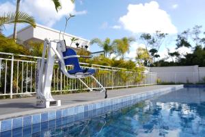 a blue chair sitting next to a swimming pool at Aconchego estrada do coco in Camaçari
