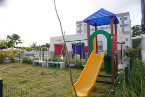 a playground with a slide in a yard at Aconchego estrada do coco in Camaçari