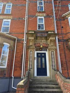 an entrance to a brick building with a blue door at A beautiful 2-bedroom Apartment in Skegness