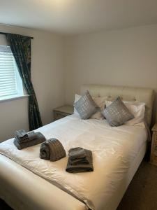 a bed with two towels on top of it at A beautiful 2-bedroom Apartment in Skegness
