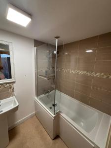 a bathroom with a shower and a tub and a sink at A beautiful 2-bedroom Apartment in Skegness +8 photos