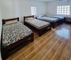 three beds in a room with wooden floors at Gaia - Casa de Playa in San Bernardo del Viento