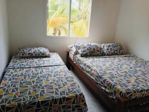 two beds sitting next to each other in a room at Gaia - Casa de Playa in San Bernardo del Viento +12 photos