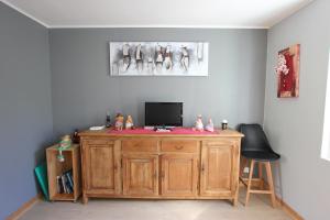 a room with a wooden desk with a tv on it at Maison au bord de l'eau avec Jacuzzi in Millau