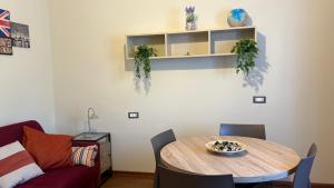 a dining room with a table and a couch at Suites Asia in Argelato