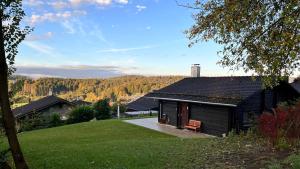 a black cabin with a view of a mountain at Ferienhaus Waldliebe in Grafenau
