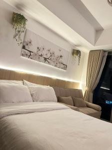 a bedroom with a white bed and a couch at 2 Bed Studio with Panoramic Sunrise View & BigBalcony in San Fernando