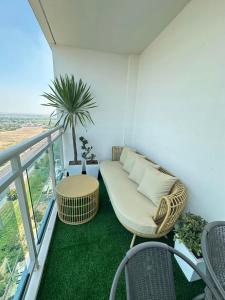 a balcony with a couch and a palm tree at 2 Bed Studio with Panoramic Sunrise View & BigBalcony in San Fernando +3 photos