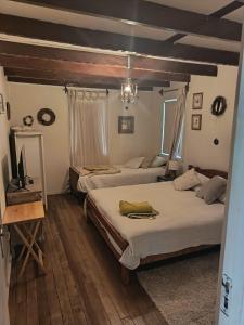 a bedroom with two beds and a television in it at Casa Krampus Hospedaje y Cervecería in Valdivia