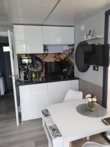 a kitchen with white cabinets and a table at Hausboot Lucky in Hattem