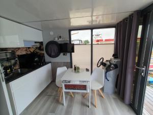 a small kitchen with a white table and chairs at Hausboot Lucky in Hattem