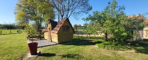a small cabin in a yard with a playground at Les cabanes du veau in Daumeray +25 photos