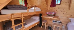 a bedroom with two bunk beds in a log cabin at Les cabanes du veau in Daumeray