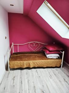 a bed in a room with a purple wall at Dom na wynajem Pasym in Pasym