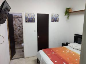 a bedroom with a bed and a bathroom with a mirror at Apartaestudio con Parqueadero in Cúcuta