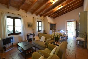 a living room with a couch and a tv at Villa Santa María Dreams AWARDED 2024 in Santa Maria del Camí