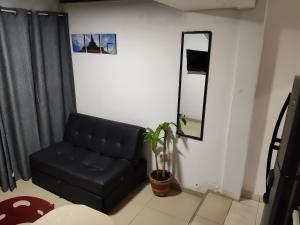 a living room with a black couch and a mirror at Apartaestudio con Parqueadero in Cúcuta