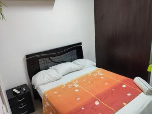 a bedroom with a bed with a black headboard at Apartaestudio con Parqueadero in Cúcuta