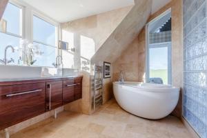 a bathroom with a large white tub and a sink at Taigh Gleusta in Angus +28 photos