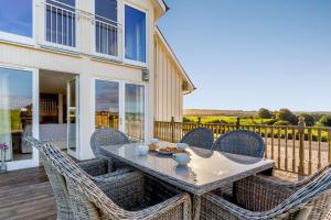 a patio with a table and chairs on a deck at Taigh Gleusta in Angus