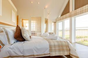 a bedroom with a large bed with white sheets and pillows at Taigh Gleusta in Angus