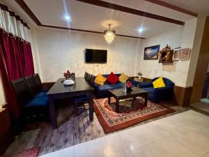 a living room with a blue couch and a table at Hexon Stays in Manāli