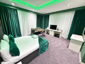 a hotel room with a large bed and a desk at Bazarstore Montin Hotel in Baku