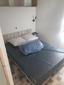 a bed with two pillows on it in a room at Camping Canet plage mobilhome 4 ou 6 personnes in Canet-en-Roussillon
