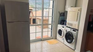 a kitchen with a washing machine and a window at Maribel's Place in Funchal