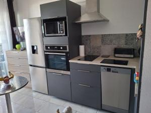 a kitchen with a refrigerator and a microwave at studio cabine tous cocooning in Gruissan